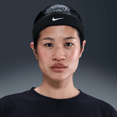 Nike Swoosh Classic headband worn by a young woman, showcasing its comfortable and stylish design in black.