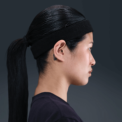 Nike Swoosh Classic black headband worn by a person with long hair, showcasing side profile view.
