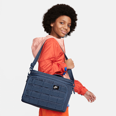 Nike Sportswear Plus lunch tote carried by a young boy, showcasing its stylish design in Diffused Blue.